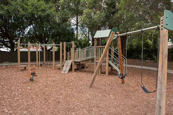 Playground with monkey bars, rocker, swings and climbing fort