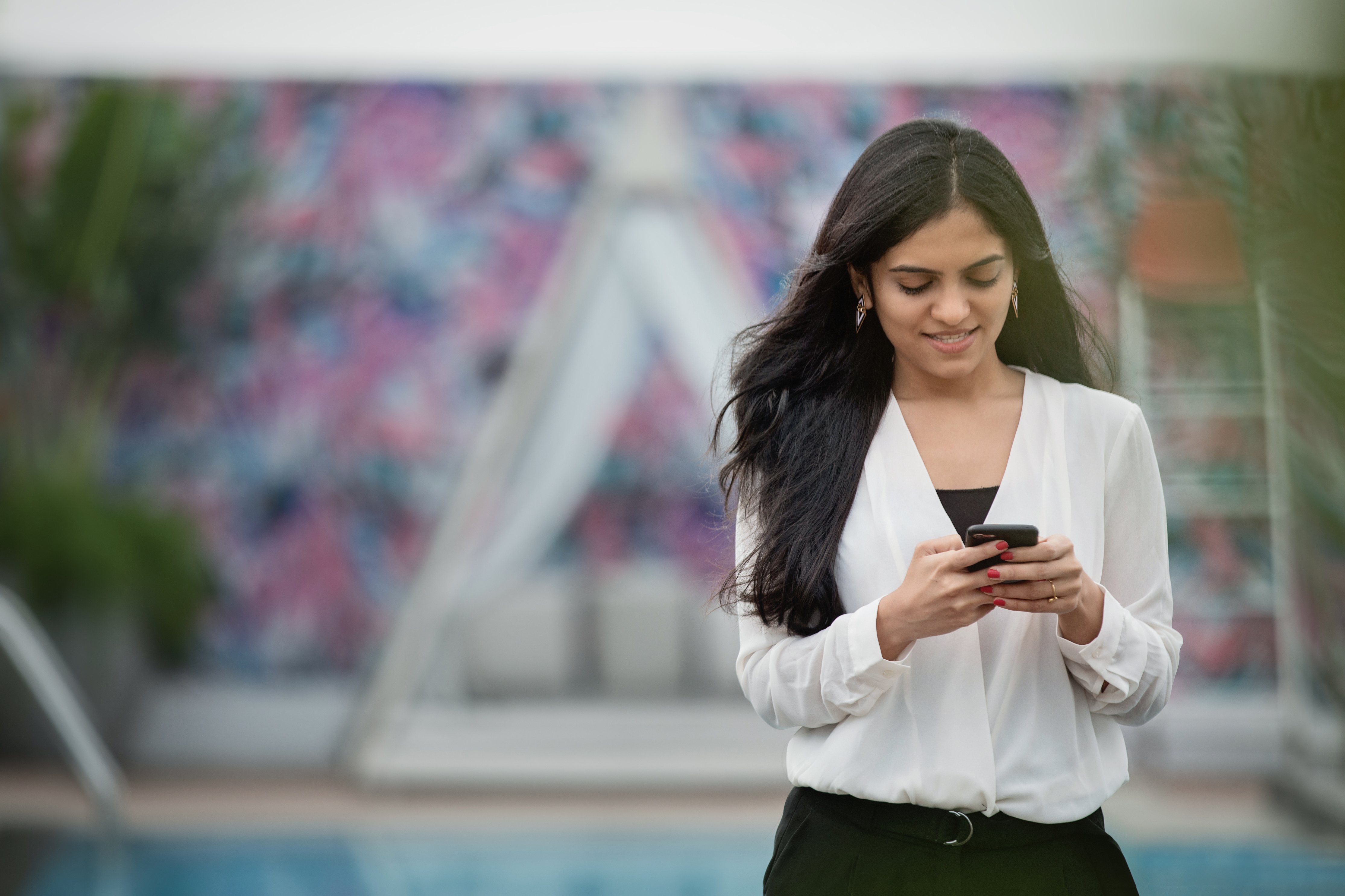 woman walking outside using mobile phone