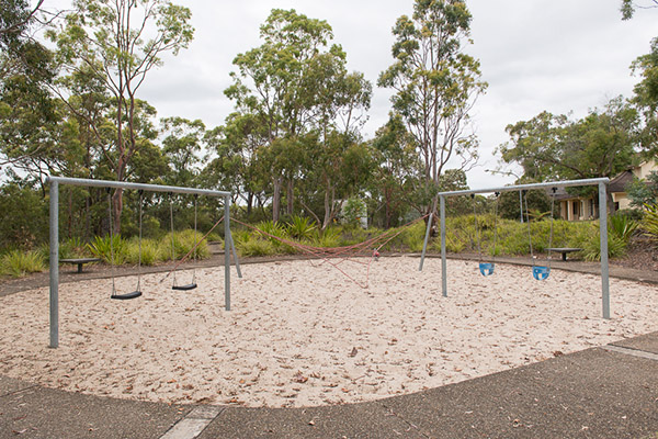 Playground with swings, climbing net and sand