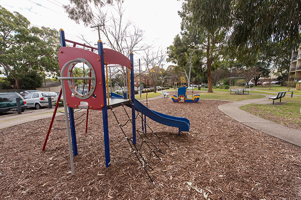 Park with play equipment, seating and trees