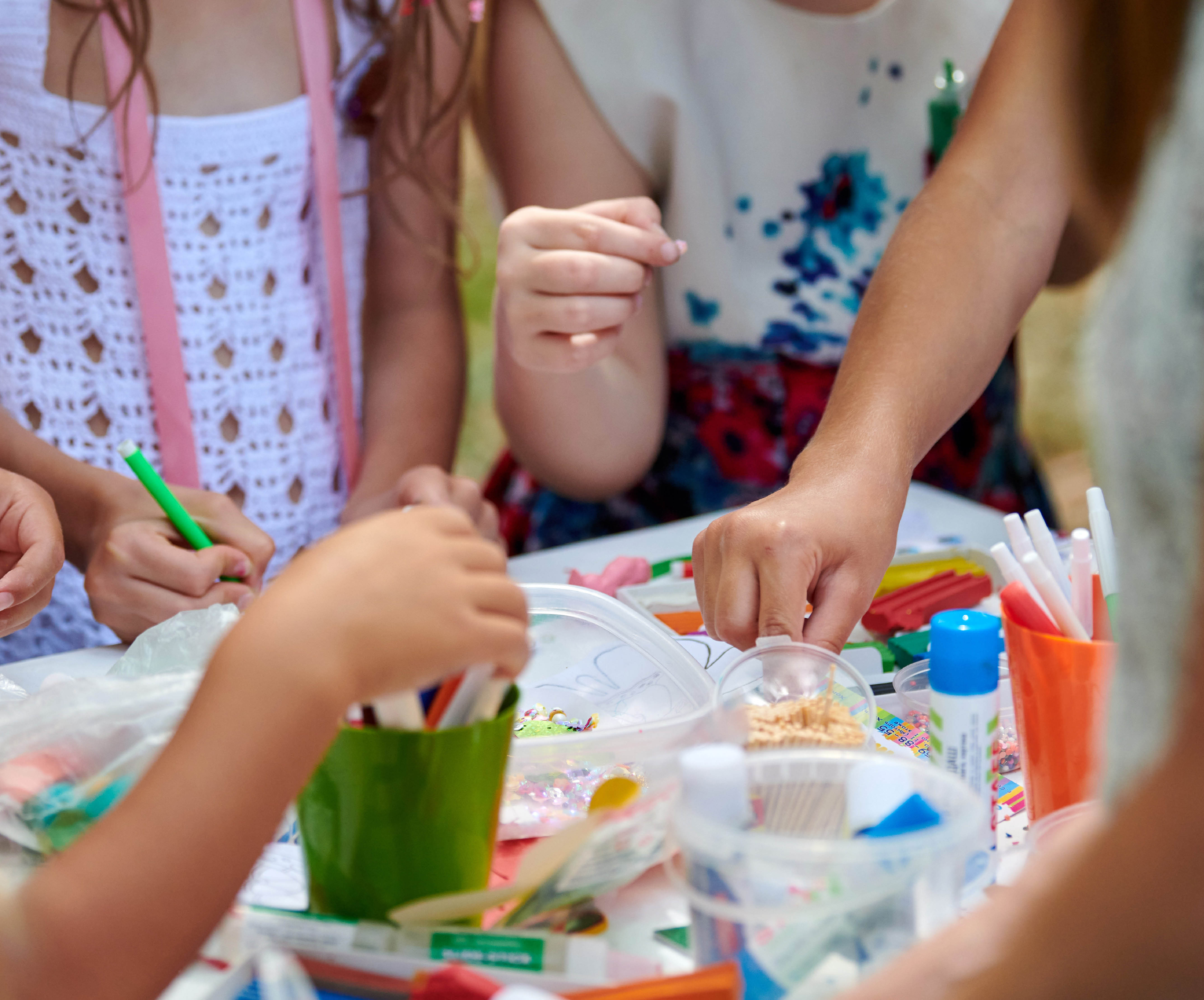 children using pens at craft table