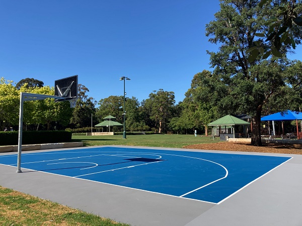 Half-court basketball court in leafy park
