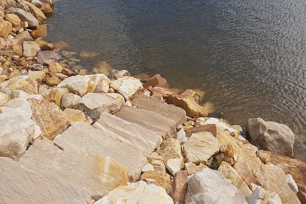 Sandstone steps down to water
