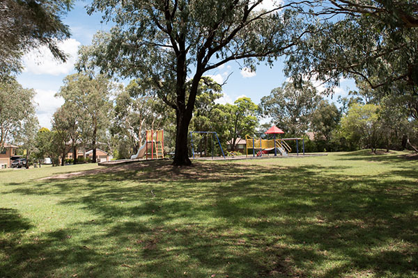 Leafy reserve with open space grassed area and playground