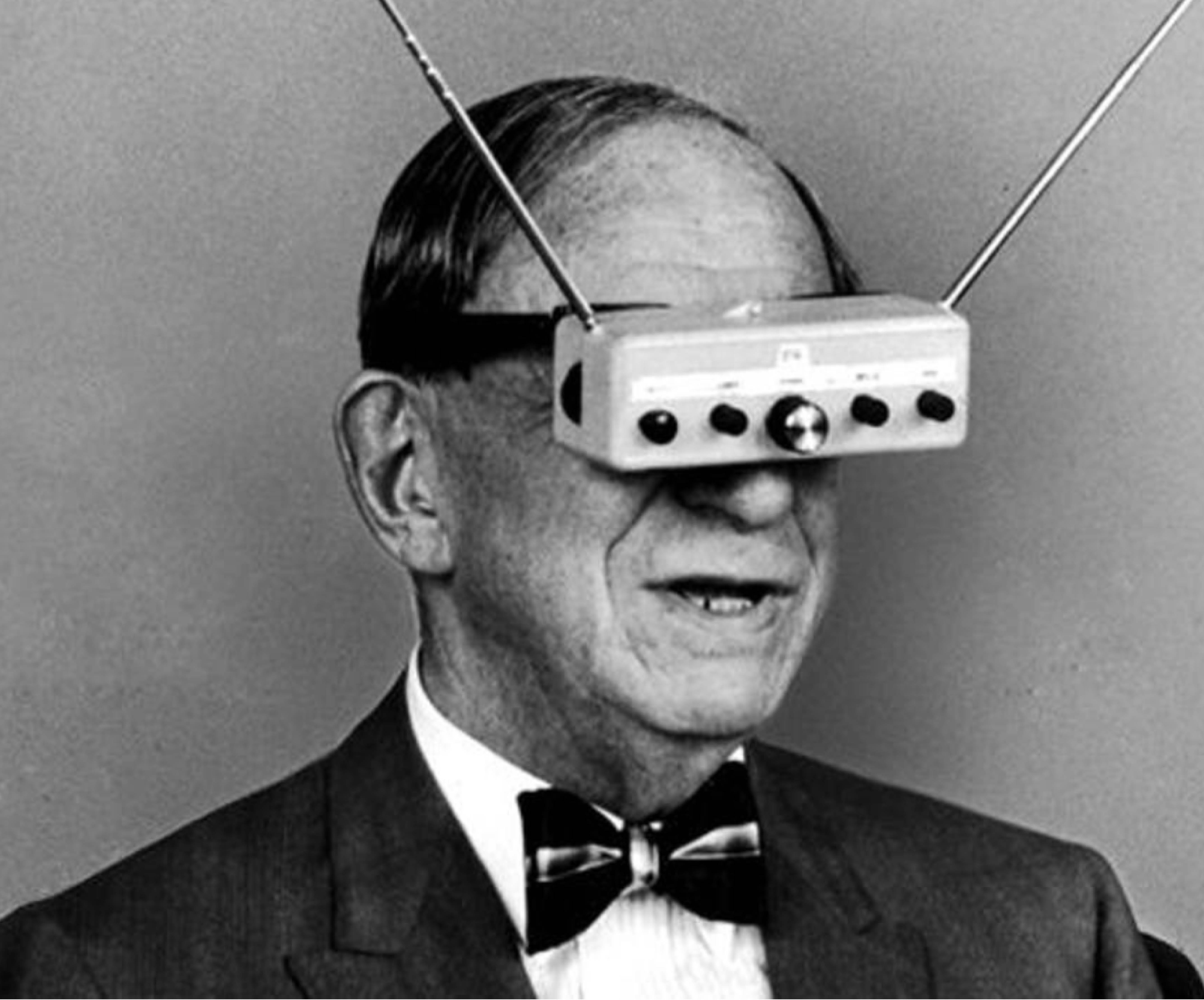 black and white image of a man in a bowtie with a goggle type invention
