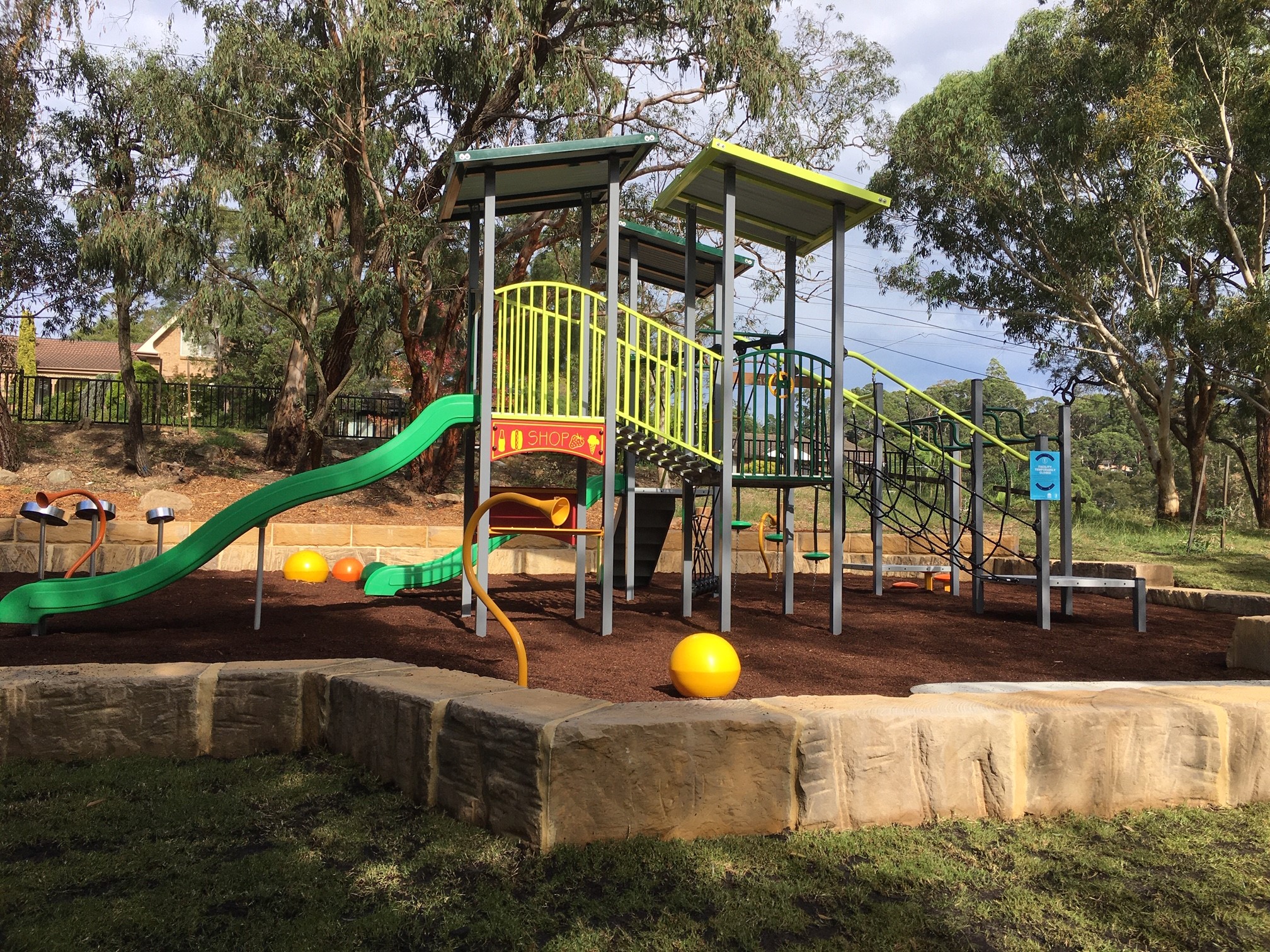 Playground with climbing fort and two slides on bark softfall