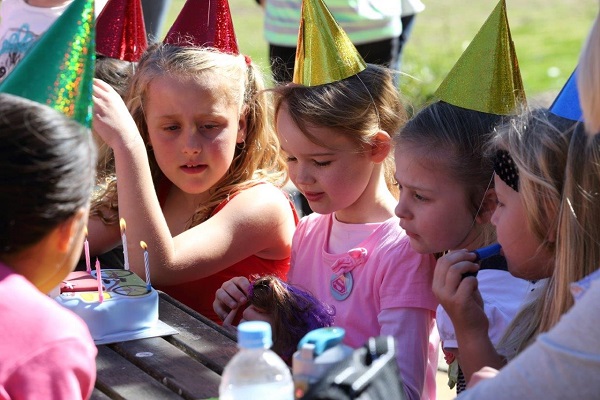 Children at park bench with party food