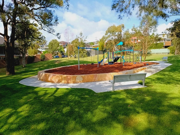 Park with playground, scooter path and grass