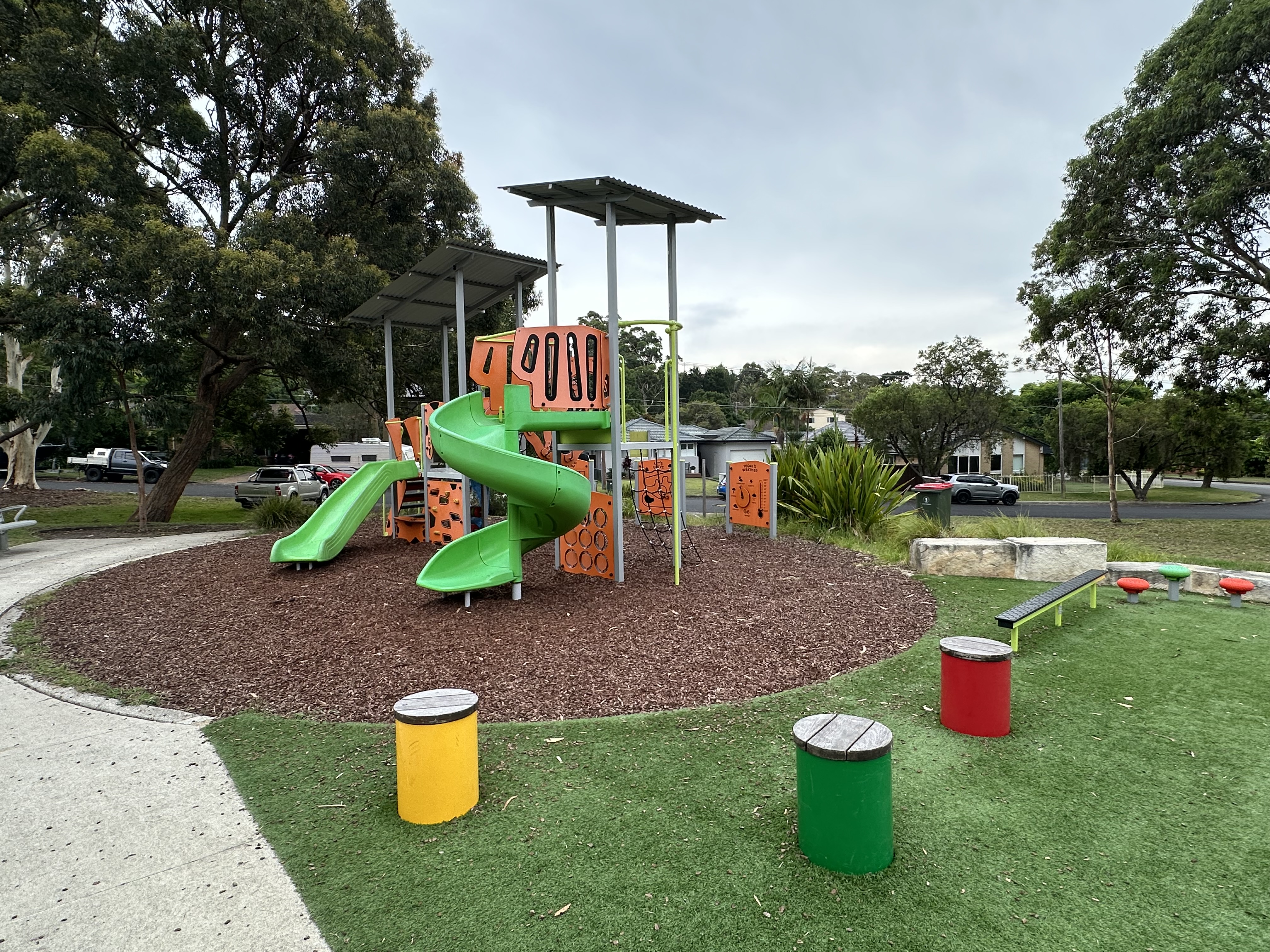 View of existing playground with coloured drums and orange equipment
