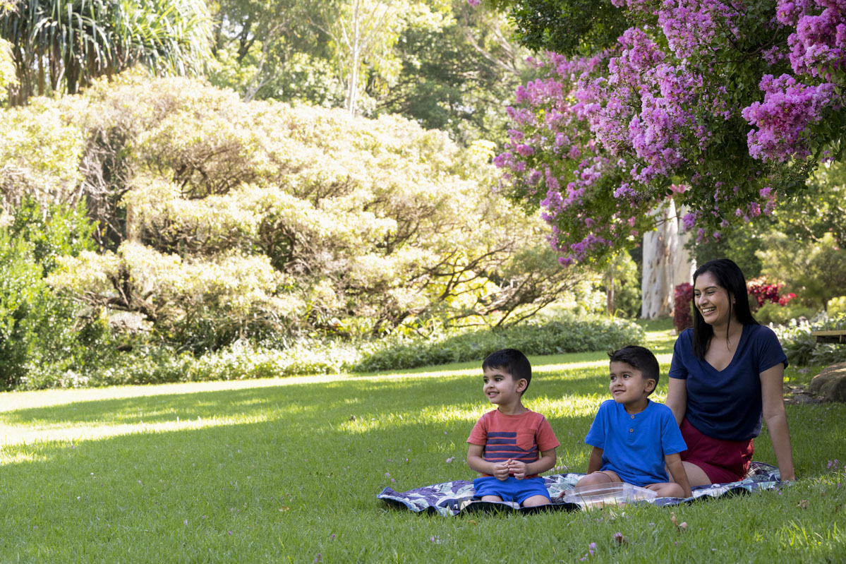 Woman with two children having a picnic in the Camellia Gardens