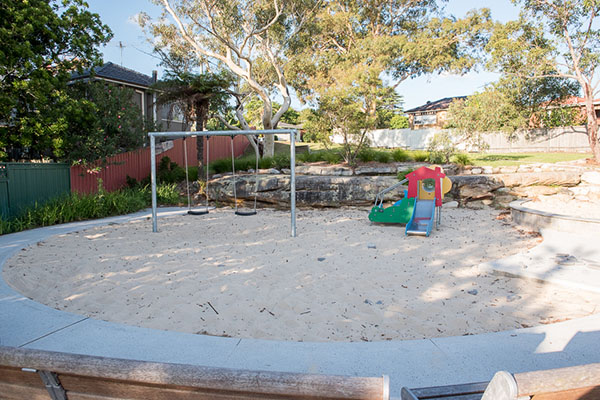 Sandy playground with swings and activity play