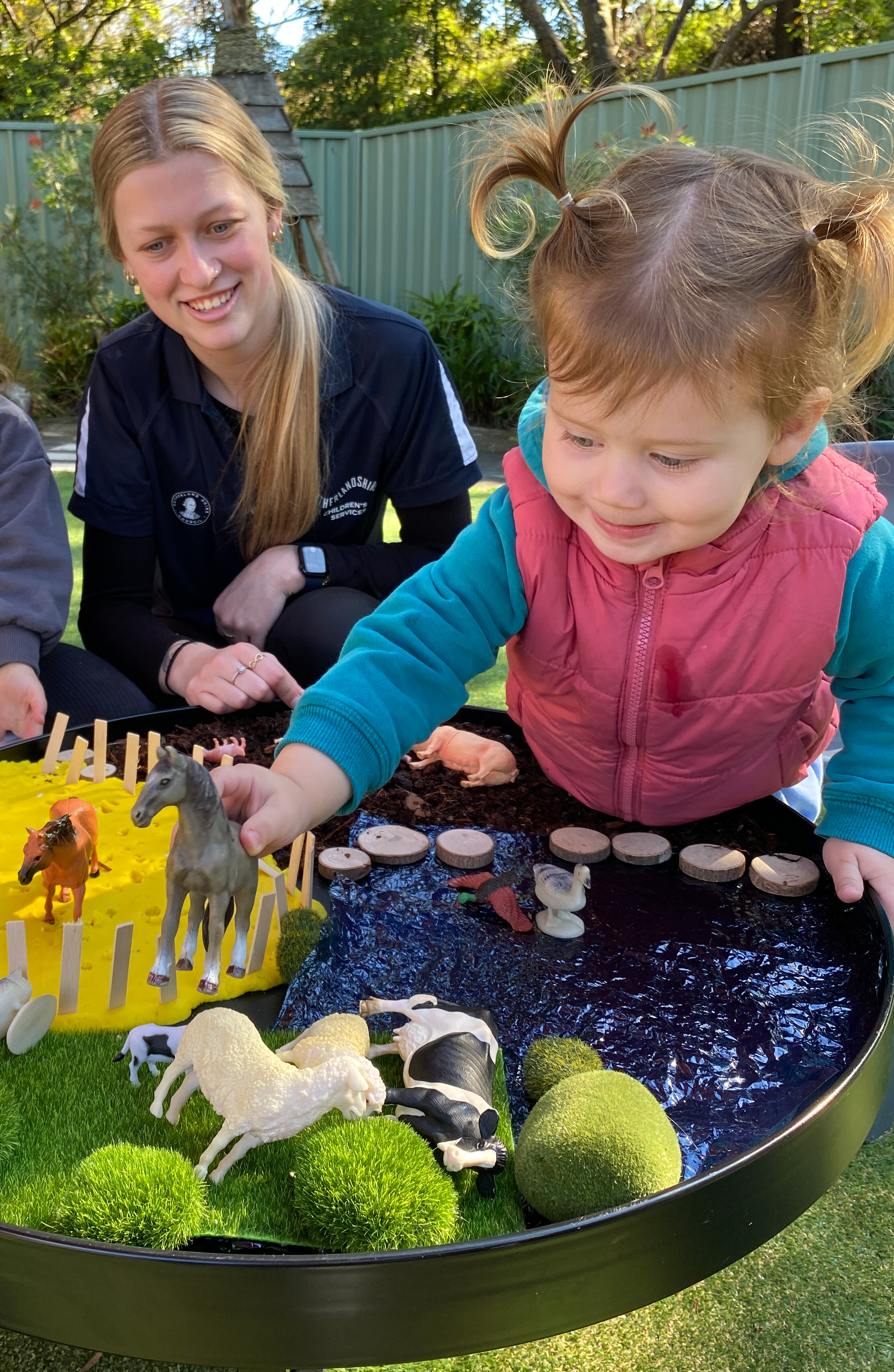 Photo of Educator and child in a centre playground 