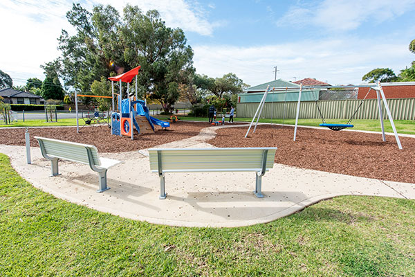Playground with bark mulch, climbing fort and basket swing