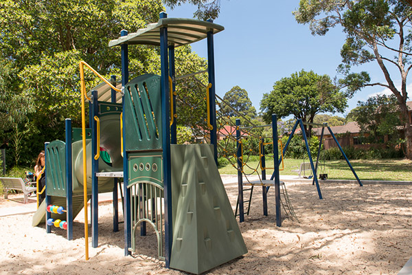 Park with climbing equipment, swings and sand softfall