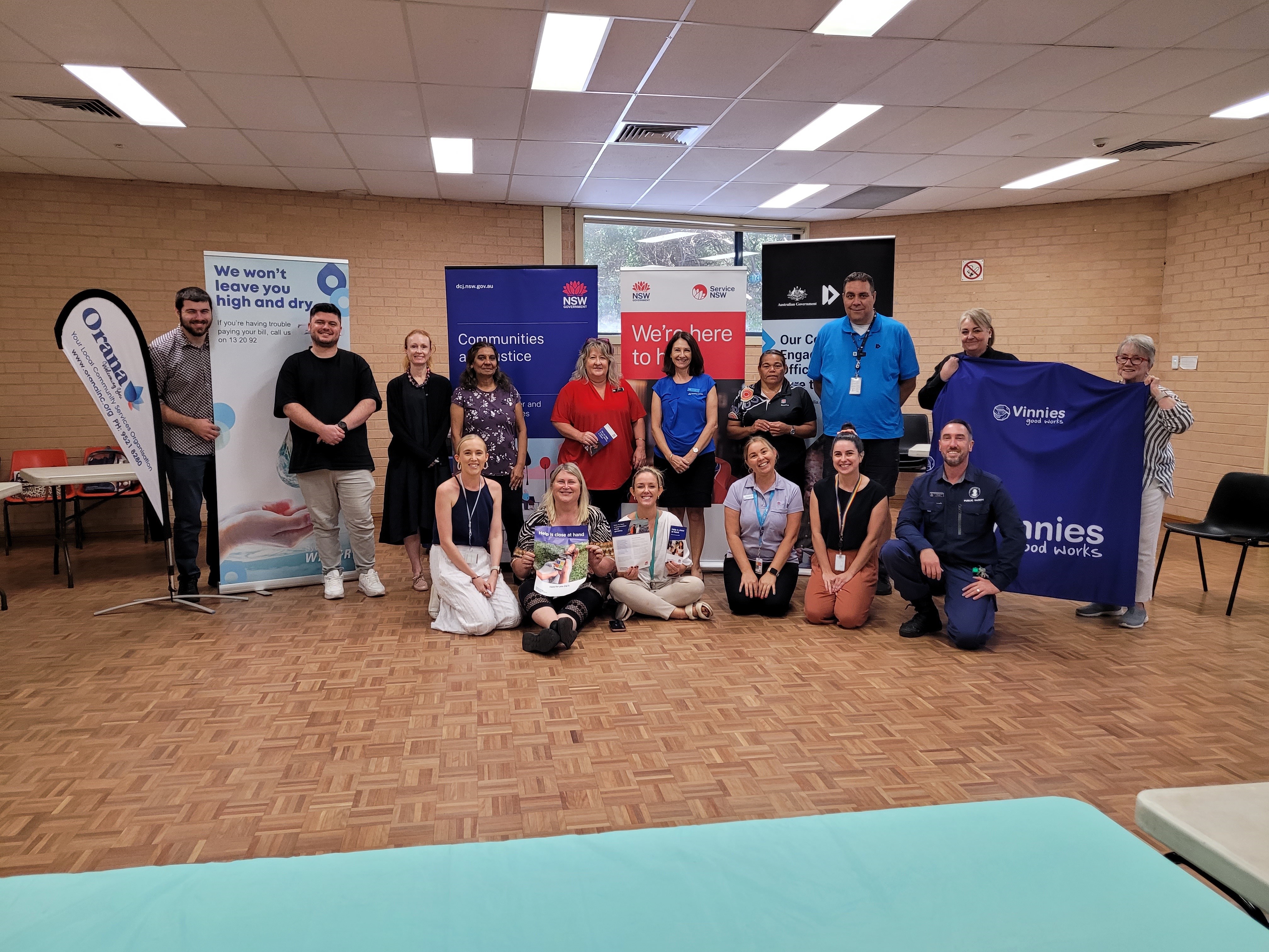 Several people in a group representing local government service providers surrounded by banners