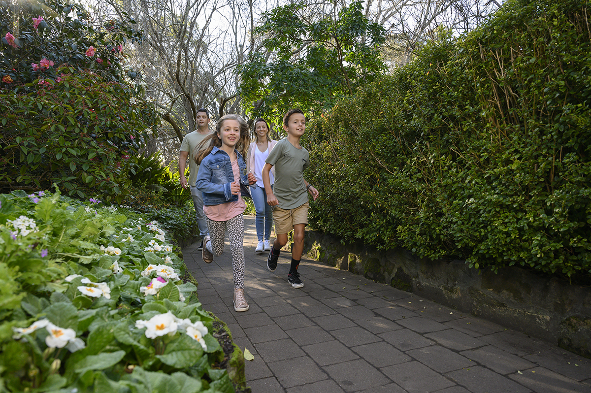 Children running along path in Camellia Gardens