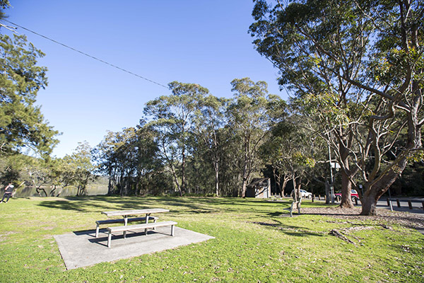 Grassed open area with seating by the river