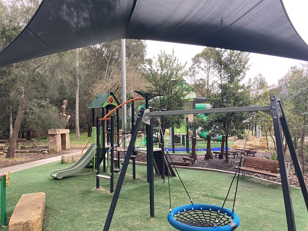 Large playground with basket swing and junior climbing frame