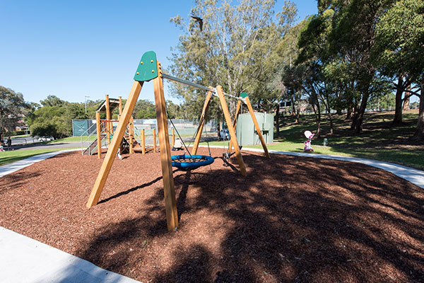 Playground with swings and climbing equipment with bark softfall