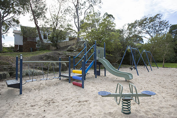 Sandy playground with slide, rocker and swings