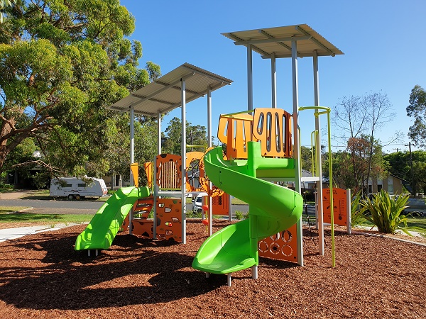 Colourful playground with climbing fort, activity panels and swings