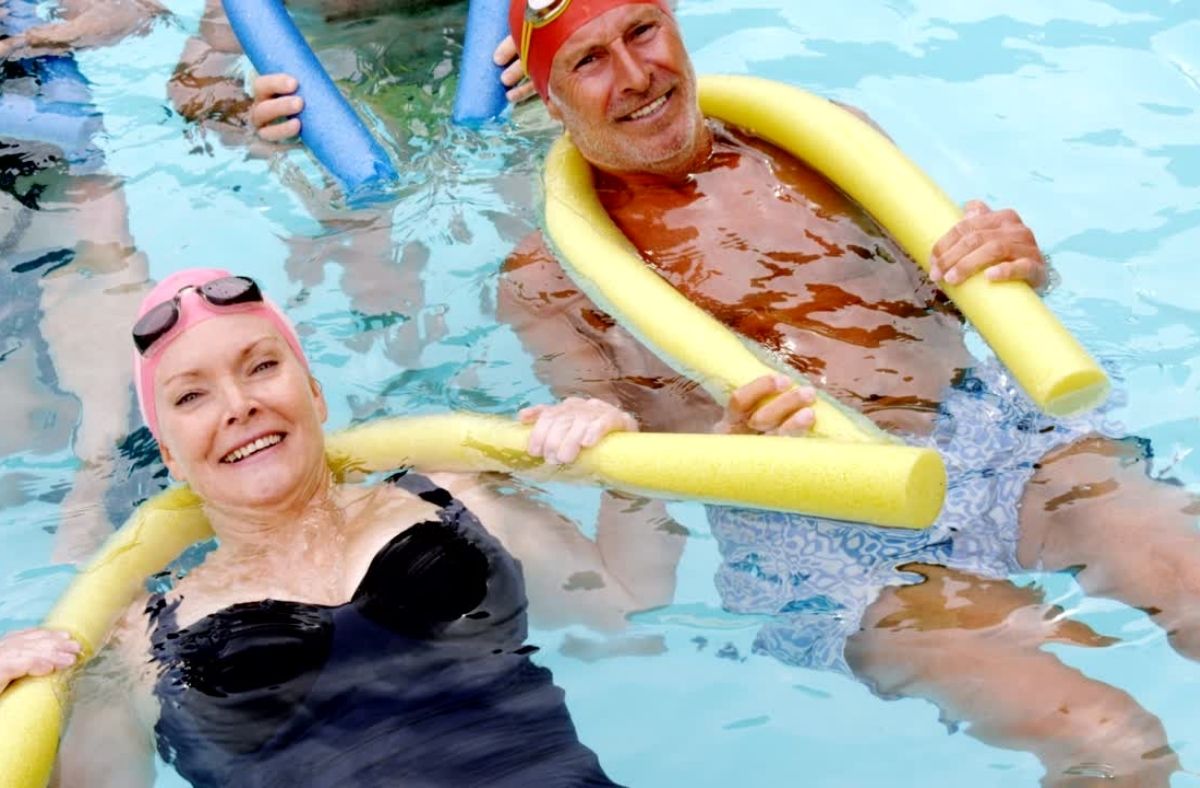 senior woman and man swimming in pool