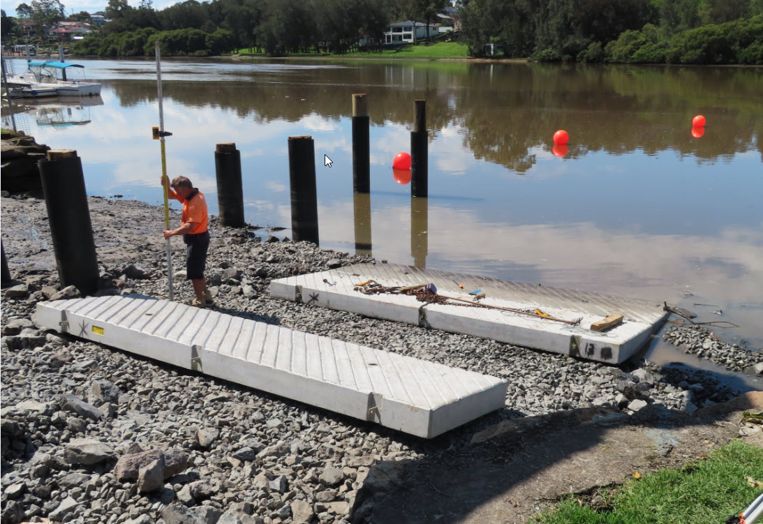 Surveyor measuring the new pre cast concrete panels  at low tide