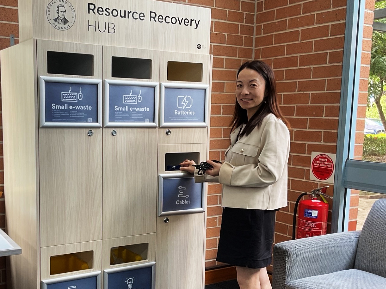 A young woman drops cables into a recycling hub