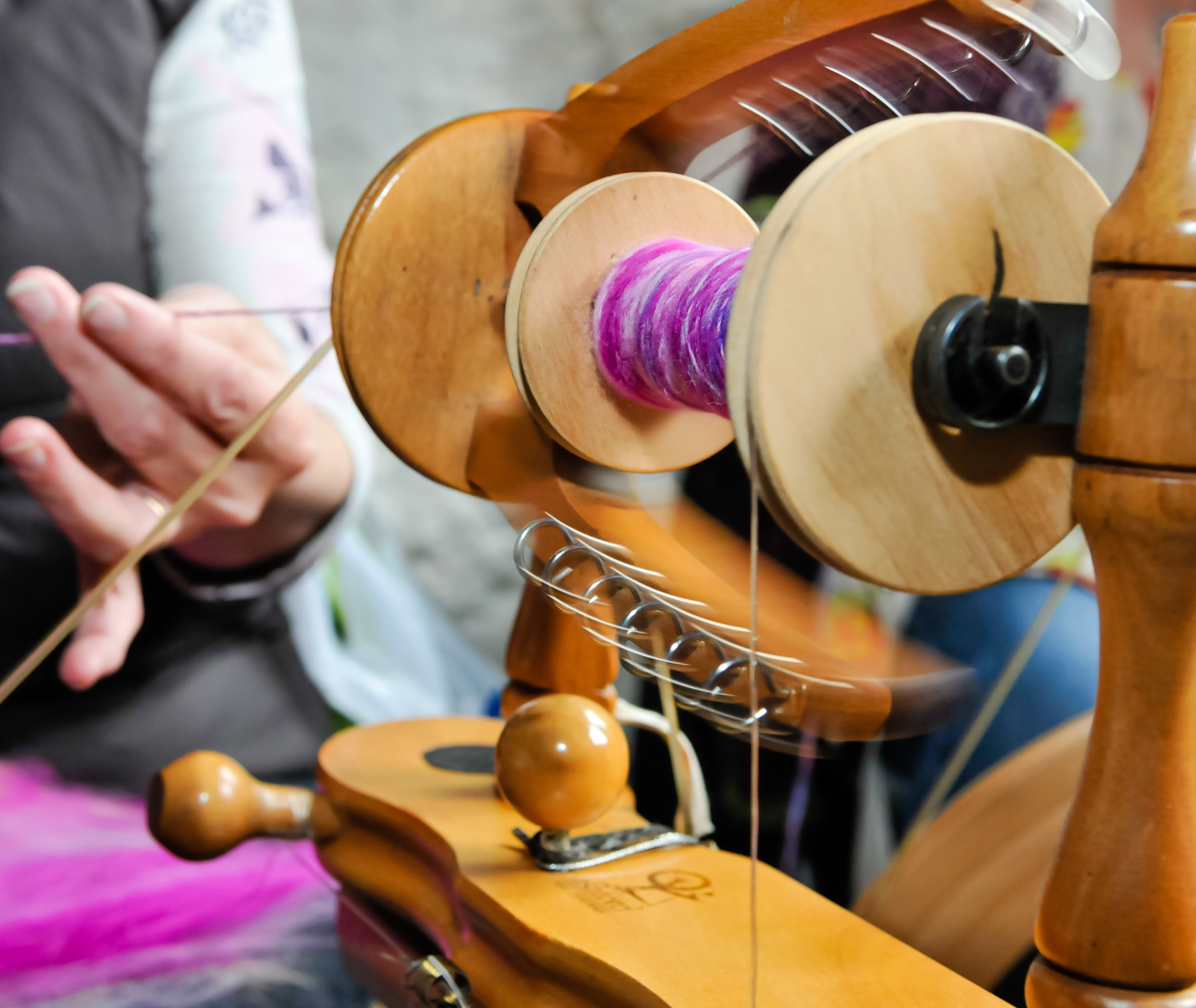woman spinning  wool yarn on a wheel