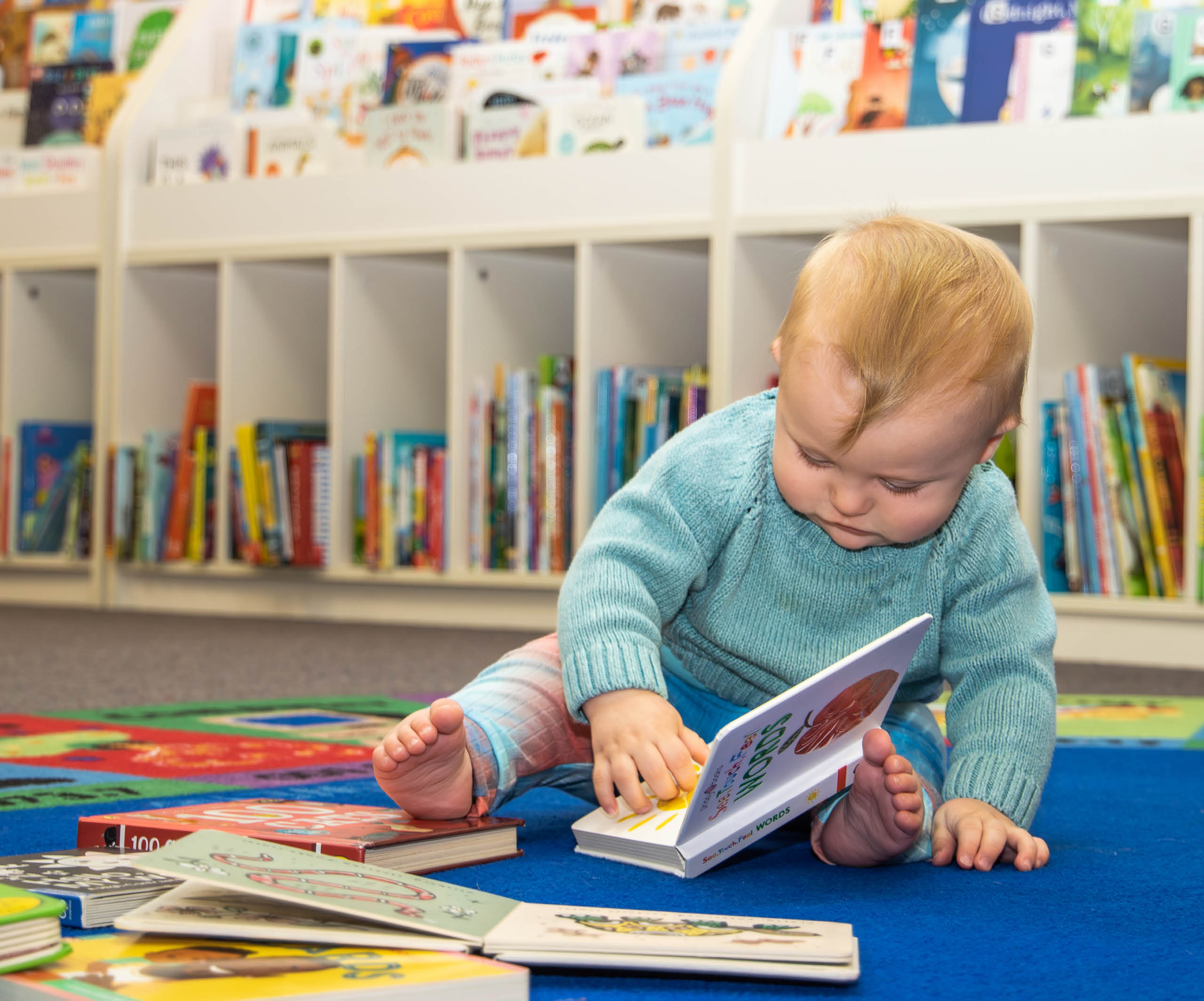 Baby boy reading board books Sylvania Library