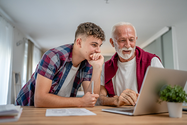 Young man with older man looking at laptop together